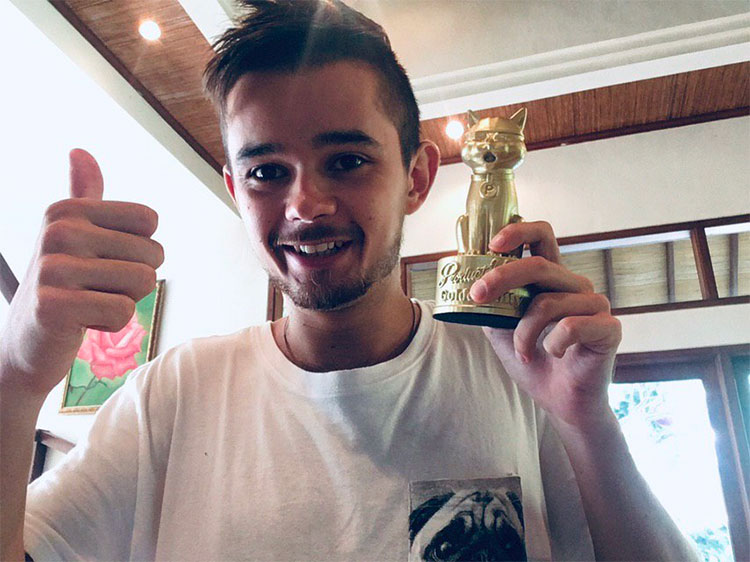 andrey azimov showing thumbs up and holding a cat souvenir