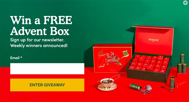 Promotion for a free Advent Box giveaway with signup form for newsletter. The Advent Box is open showing compartments, with tea items and a cup beside it. Email input and "Enter Giveaway" button included.