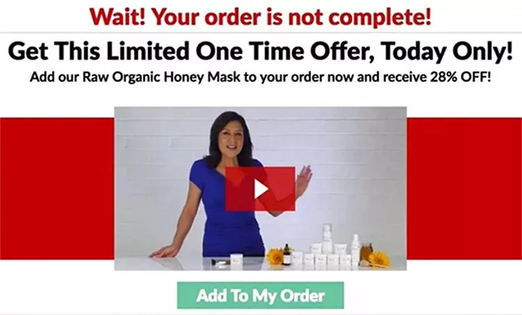 A woman in a blue dress stands behind a table displaying skincare products. Text prompts "Wait! Your order is not complete!" and offers a raw organic honey mask at 28% off. A large "Add To My Order" button is below.